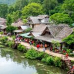 Pemandangan desa dengan rumah tradisional dan aktivitas budaya.